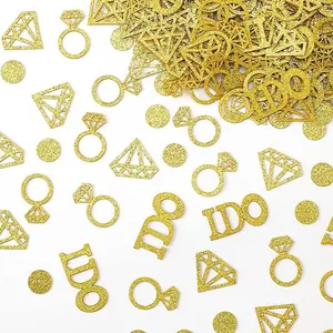 Detailed close-up view of gold glitter engagement confetti with I DO and ring shapes
