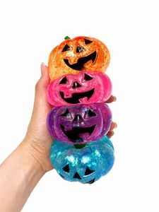 Primer plano de cuatro coloridos juguetes blandos de calabaza de Halloween con purpurina