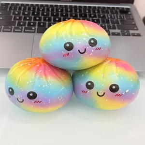 Gros plan de trois jouets anti-stress mignons en forme de brioche arc-en-ciel avec sourires.