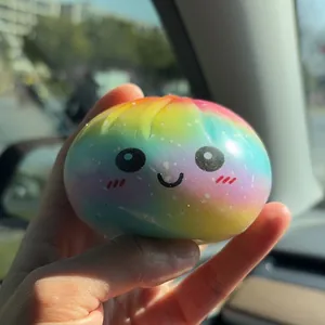Gros plan d'un jouet squishy baozi arc-en-ciel arborant un visage de dessin animé mignon.