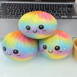 Détails de trois jouets squishy en forme de brioche arc-en-ciel avec visages souriants.