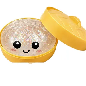 Simpatico giocattolo antistress a forma di panino al vapore glitterato in un cestino giallo