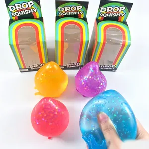 Detalle de juguetes squishy de gota con purpurina en cajas de regalo de arcoíris