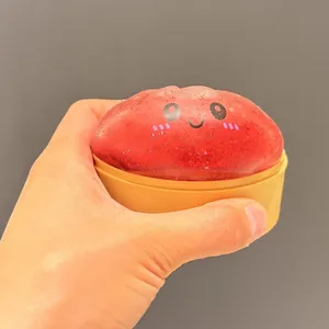 Détail d'un mignon petit pain rouge scintillant pressé à la hand pour soulager le stress