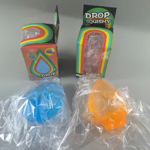 Vista detallada de juguetes blandos con purpurina azul y naranja con sus cajas.