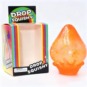 Detalle del juguete squishy de gota naranja con purpurina y caja de regalo de arcoíris