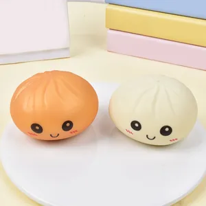Detailed view of two cute steamed bun squishy toys with smiling faces on a white plate