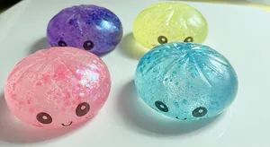 Close-up of colorful glitter bun squishy toys with cute smiley faces