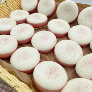 Vue détaillée de plusieurs squishies mousse pêche blanche dans un panier rustique