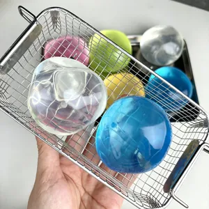 Primer plano de bolas de juguete antiestrés transparentes y coloridas en una cesta de metal.