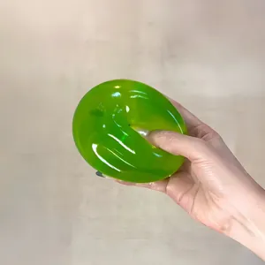 Detailaufnahme einer Hand, die ein grünes Stressabbau-Spielzeug aus TPR-Weichgummi drückt