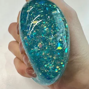 Makroaufnahme von schimmerndem Polarlicht-Glitzer in einem blaugrünen Quetschball.