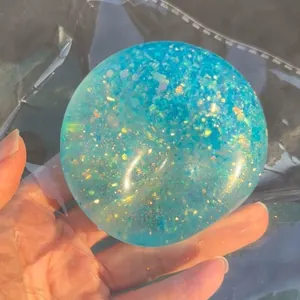 Detailaufnahme eines blauen Aurora-Glitzer-Quetschballs zur Stressbewältigung und Entspannung