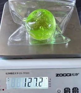 Detailed macro shot of a green apple squeeze stress toy weighing 127.2g on a precision scale.