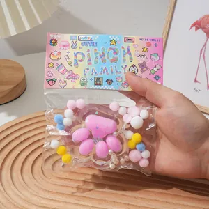 Macro detail of crystal cat paw squishy with colorful pom-poms in cute packaging