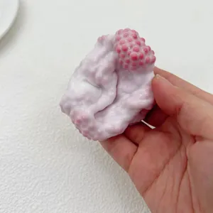 Close-up detail of a milky white pearl textured squishy stress relief toy held in hand