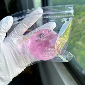 Detail shot of a translucent pink apple-shaped squishy toy in clear packaging