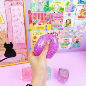 Macro view of a hand squeezing a 5cm purple glitter ice cube squishy stress relief toy