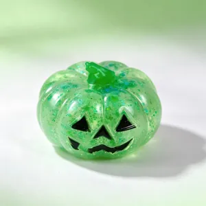 Translucent green Halloween pumpkin squishy toy with glitter and Jack-o'-lantern face