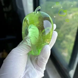 Macro view of a translucent green apple stress relief toy being held with a gloved hand