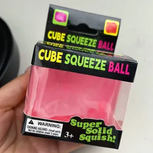 Gros plan d'un jouet balle antistress rose en forme de cube dans son emballage noir