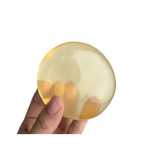 Pelota antiestrés artesanal de aceite de coco de alta transparencia sostenida en mano