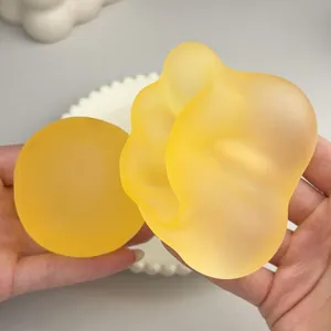 Primo piano di giocattoli squishy gialli satinati e modellabili con consistenza morbida.
