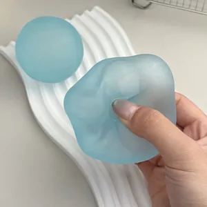 Dettaglio di una pallina antistress blu opaca all'olio di cocco mentre viene schiacciata