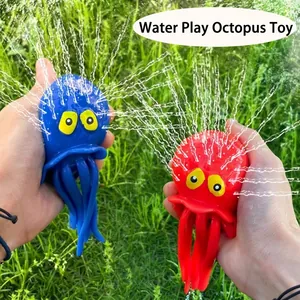 Gros plan de jouets pieuvre rouge et bleu pulvérisant des jets d'eau dans un jardin extérieur.