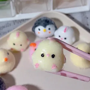 Close-up of a soft yellow animal chick squishy toy held by pink tweezers for stress relief