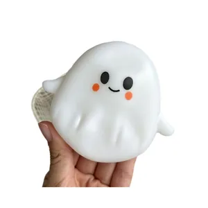 Lindo juguete antiestrés de fantasma de Halloween sostenido en la mano sobre fondo blanco puro