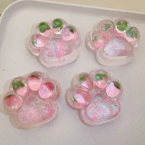Close-up of pink translucent strawberry cat paw squishy toys with glitter