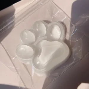 Primer plano de un juguete squishy gigante traslúcido con forma de pata de gato en su envase