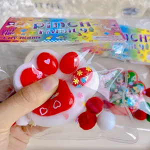 Nahaufnahme eines bunten Weihnachtskatzenpfoten-Squishy-Spielzeugs in der Tasche