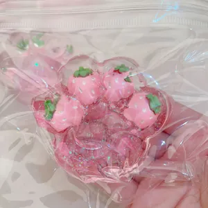 Detailed view of the pink strawberry cat paw squishy toy inside its clear plastic bag