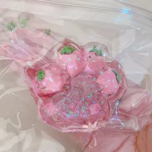 Close-up of a glittery pink strawberry cat paw squishy toy in clear plastic bag