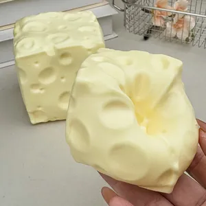 Main pressant un jouet sensoriel réaliste en forme de fromage jaune pour le stress