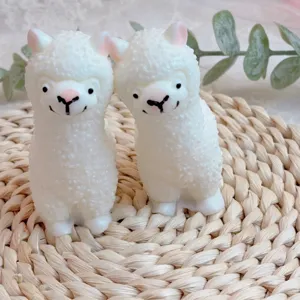 Dos adorables juguetes para apretar de alpaca blanca sobre un tapete tejido para el estrés