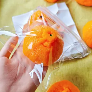 Vista detallada de un juguete blando de naranja realista en un empaque plástico