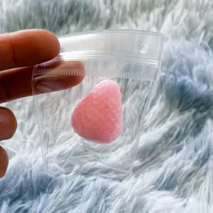 Detailed view of a pink strawberry stress relief squishy toy in clear plastic packaging