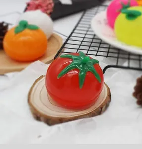 Vista detallada de un juguete de bola de agua antiestrés con forma de tomate rojo.