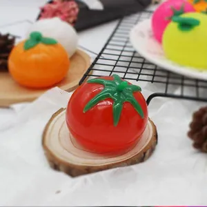 Primer plano de un juguete blando con forma de tomate sobre base de madera natural