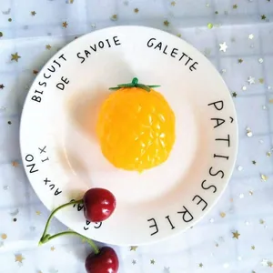 Vista detallada de un juguete antiestrés con forma de piña sobre un plato decorativo.