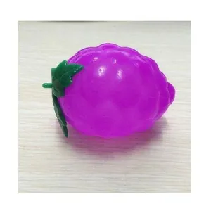 Juguete antiestrés con forma de uva morada sobre madera