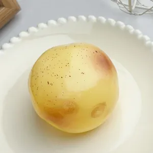 Makroansicht eines realistischen gelben Kartoffel-Squishy-Spielzeugs auf einem dekorativen Teller