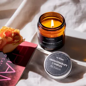 Détail d'une bougie parfumée au bois de santal rose allumée dans un bocal en verre ambré