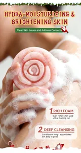 Dettaglio del sapone natalizio rosa a forma di rosa che crea una ricca schiuma bianca.