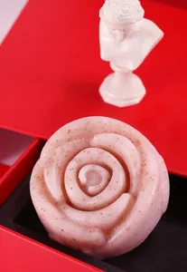 Vista macro dettagliata di un sapone artigianale rosa a forma di rosa con particelle di niacinamide