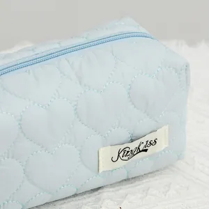 Detalle del patrón acolchado de corazones en neceser azul claro