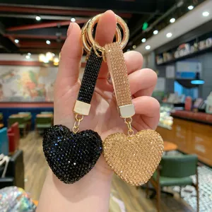 Close-up of elegant black and gold rhinestone heart charms for bags and car keys